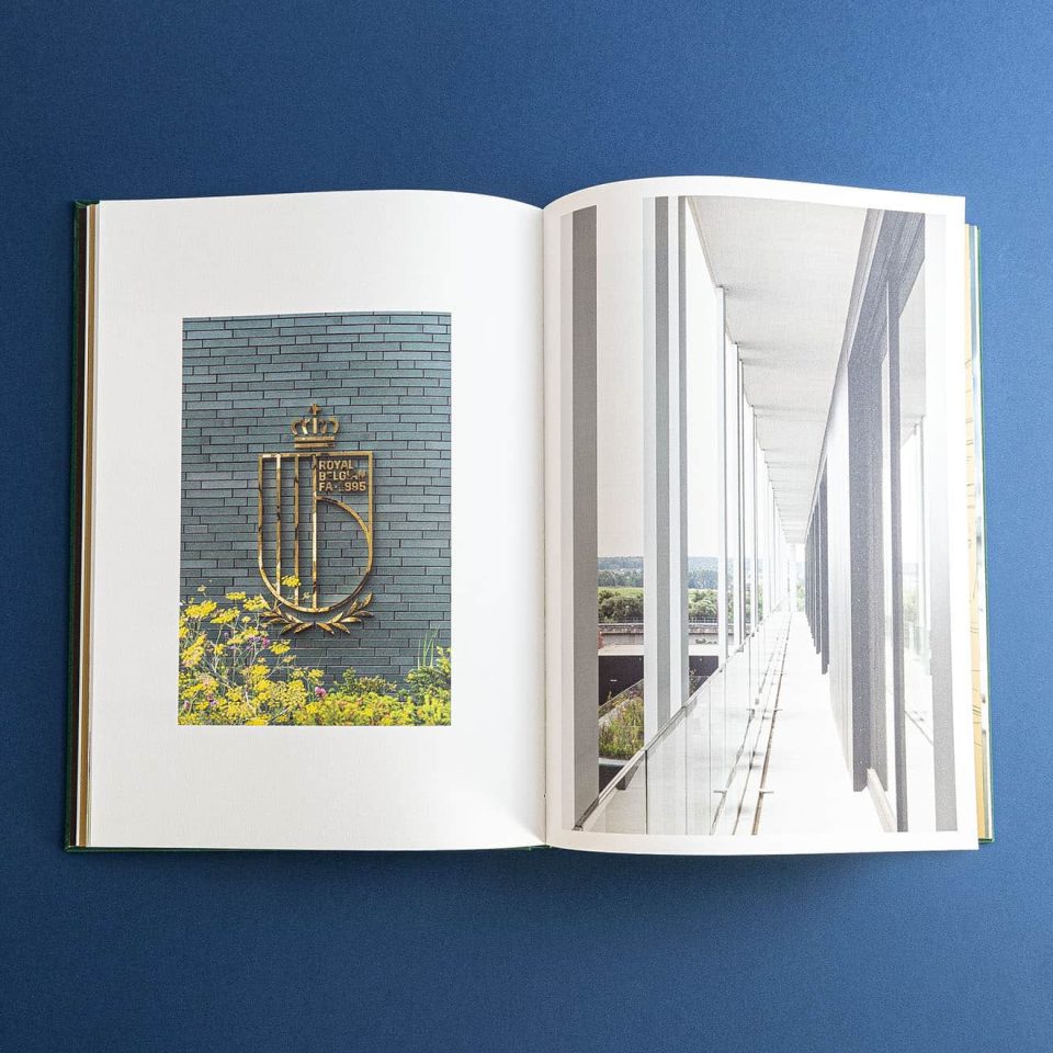 open hardcover boek van Belgische voetbalbond met foto's van de nieuwe gebouwen